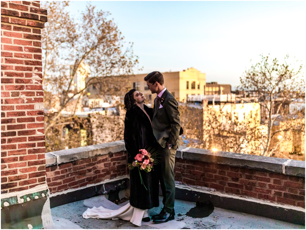 The bride and groom pose on the rooftop.
