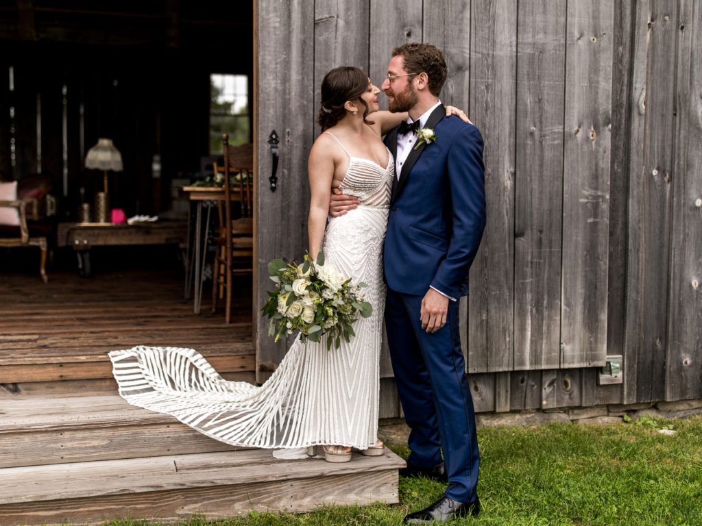 The couple embraces on the steps of the barn.