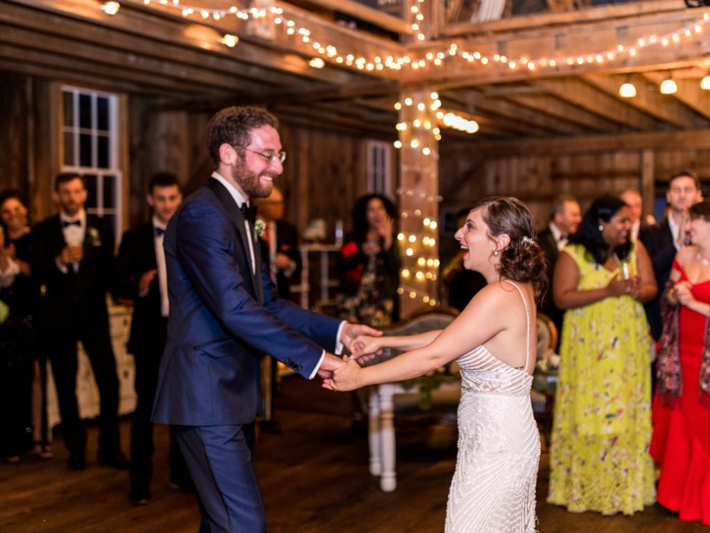 The bride and groom share a first dance in the barn.